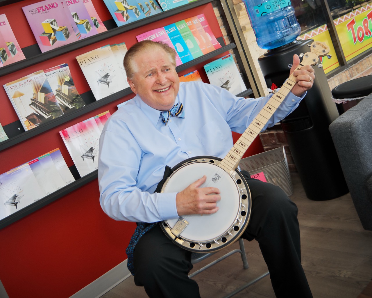 banjo instructor playing his banjo in the lobby of a school