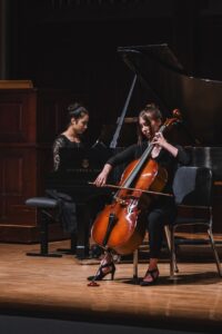 Female cellist with pianist on stage