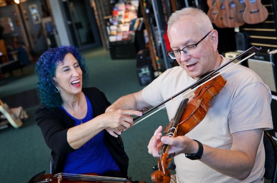 violin instructor and adult violin student having fun in a lesson playing the violin