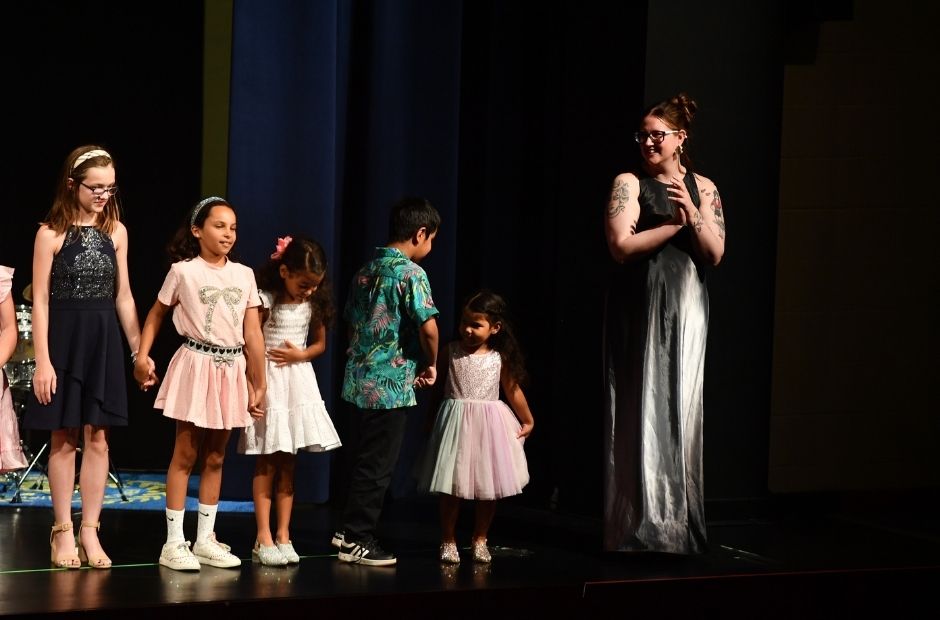 recital photo with students standing on stage ready to bow